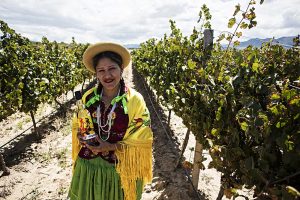 bolivian-woman-with-singani-63-bottle-in-field